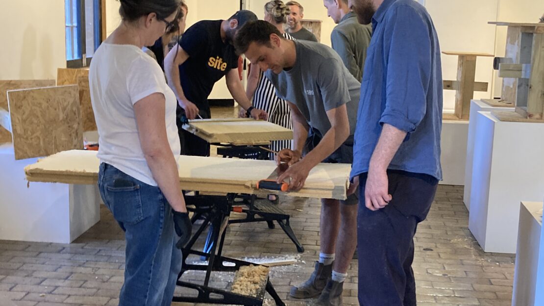 People undergoing retrofit training, in a room with workbenches.